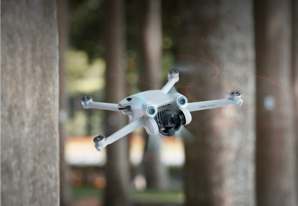 Drone Dri mini 3 volant à travers les arbres dans une forêt