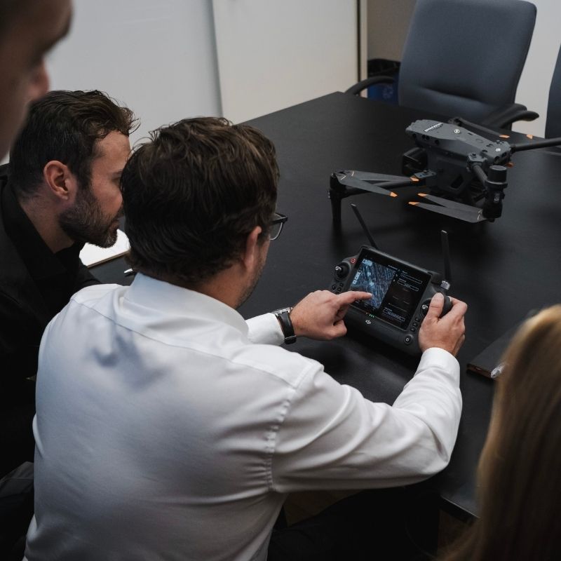 Équipe utilisant un contrôleur pour planification de vol de drone