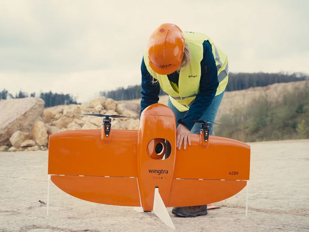 Aile volante Wingtra One Gen II posée au sol avec un technicien en arrière