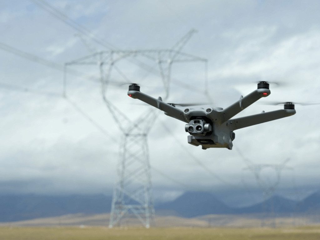 Drone in flight inspecting high-voltage power lines