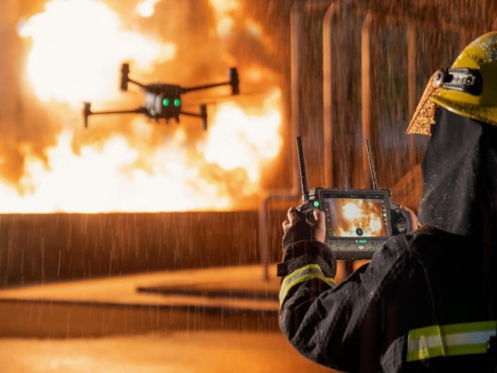 Pompier pilotant un drone DJI face à un incendie en pleine intervention.