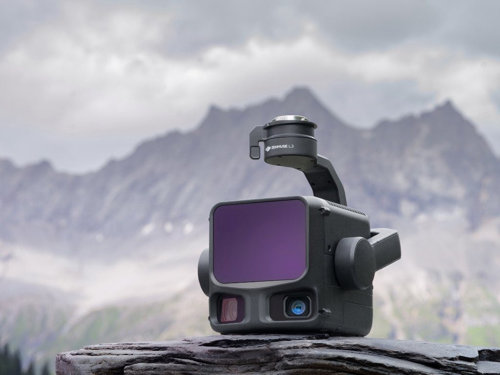 Capteur LiDAR DJI Zenmuse L3 posé sur un rocher, avec une vue de montagne en arrière-plan